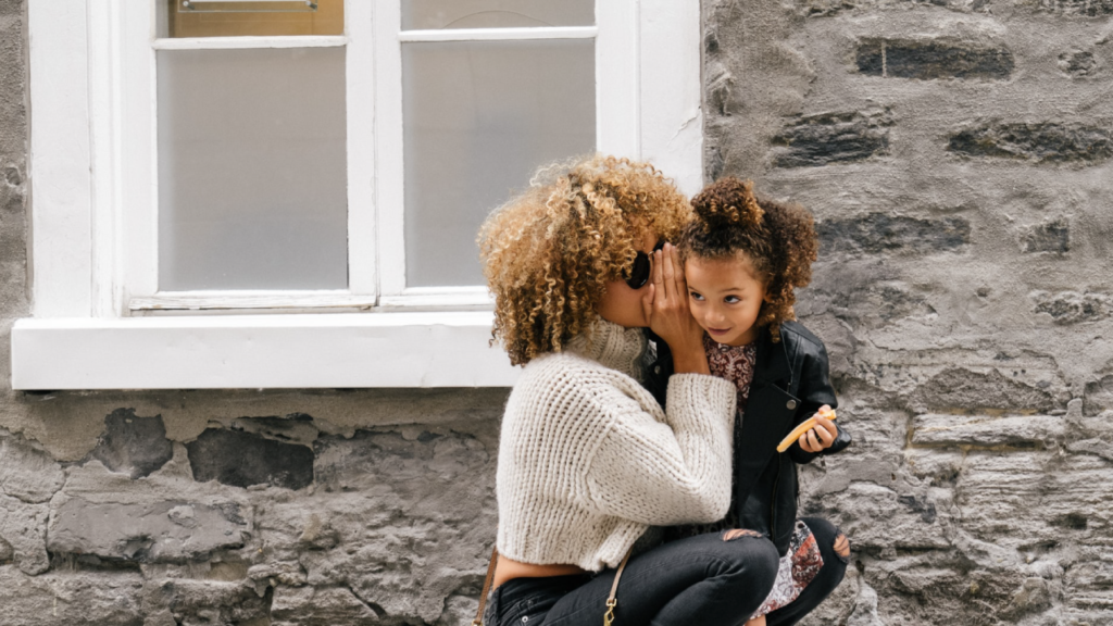 woman telling secret young daughter family outside